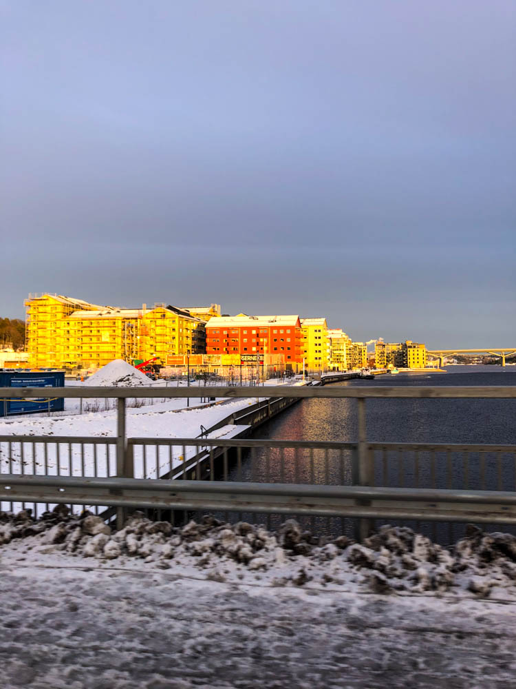 Ein paar Gebäude in Sundsvall werden von der Abendsonne angeschienen. Foto entstanden beim Fahren