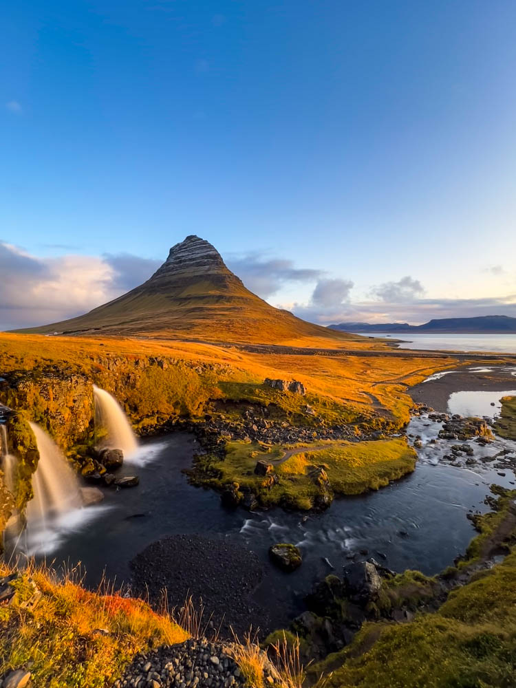 Berg Kirkjufell und Wasserfälle im Westen von Island von Morgensonne erleuchtet.