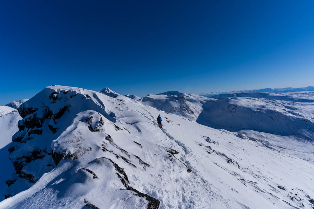 Verschneite Berglandschaft mit kräftig blauem Himmel auf Senja. Splitboardtour bzw. Skitour auf Skolpan. Tourengehen und Nordlichter