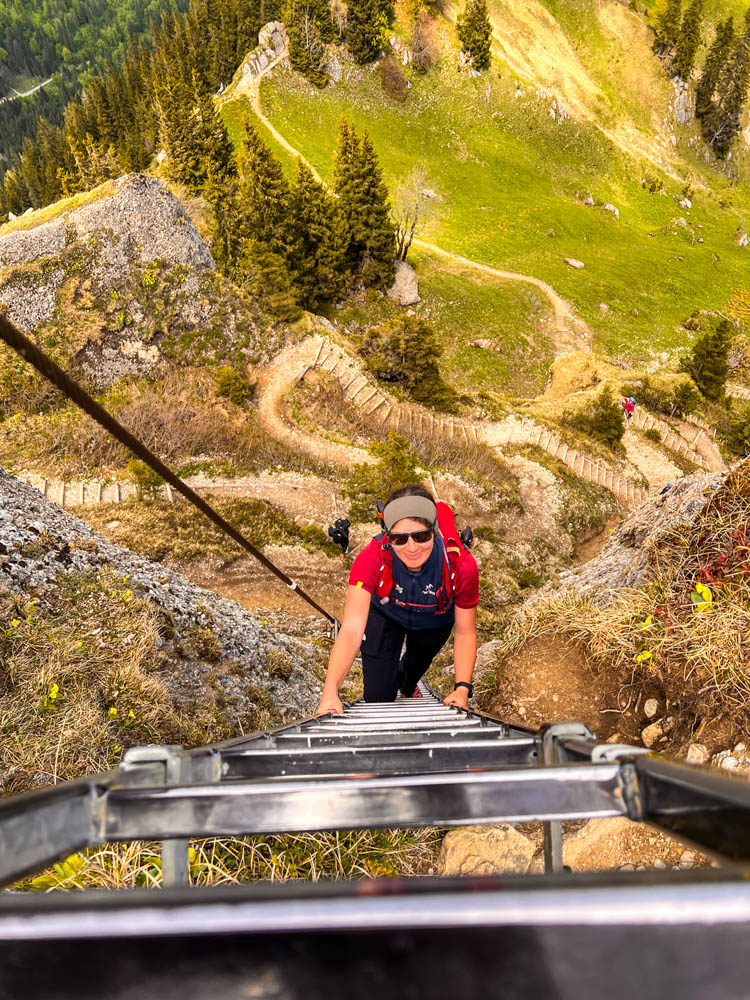 Melanie bei einer Tageswanderung in den Alpen. Sie klettert eine Leiter nach oben.